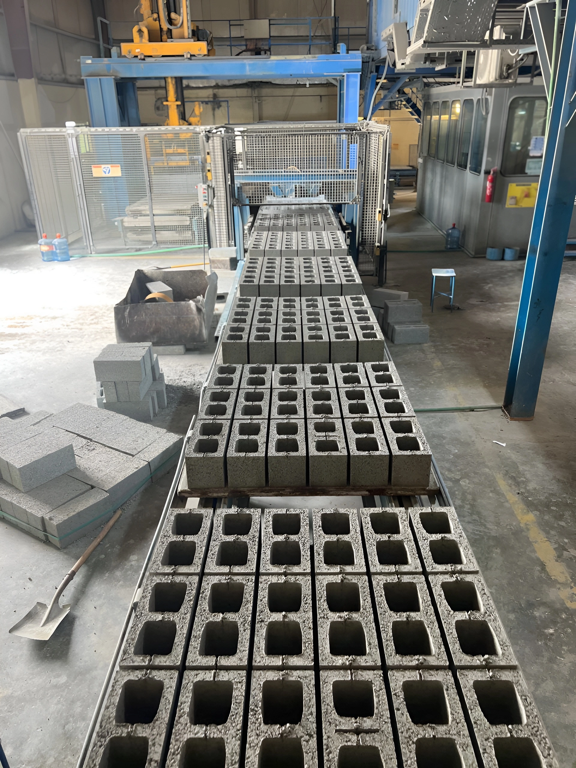 Concrete hollow blocks freshly produced on the manufacturing conveyor